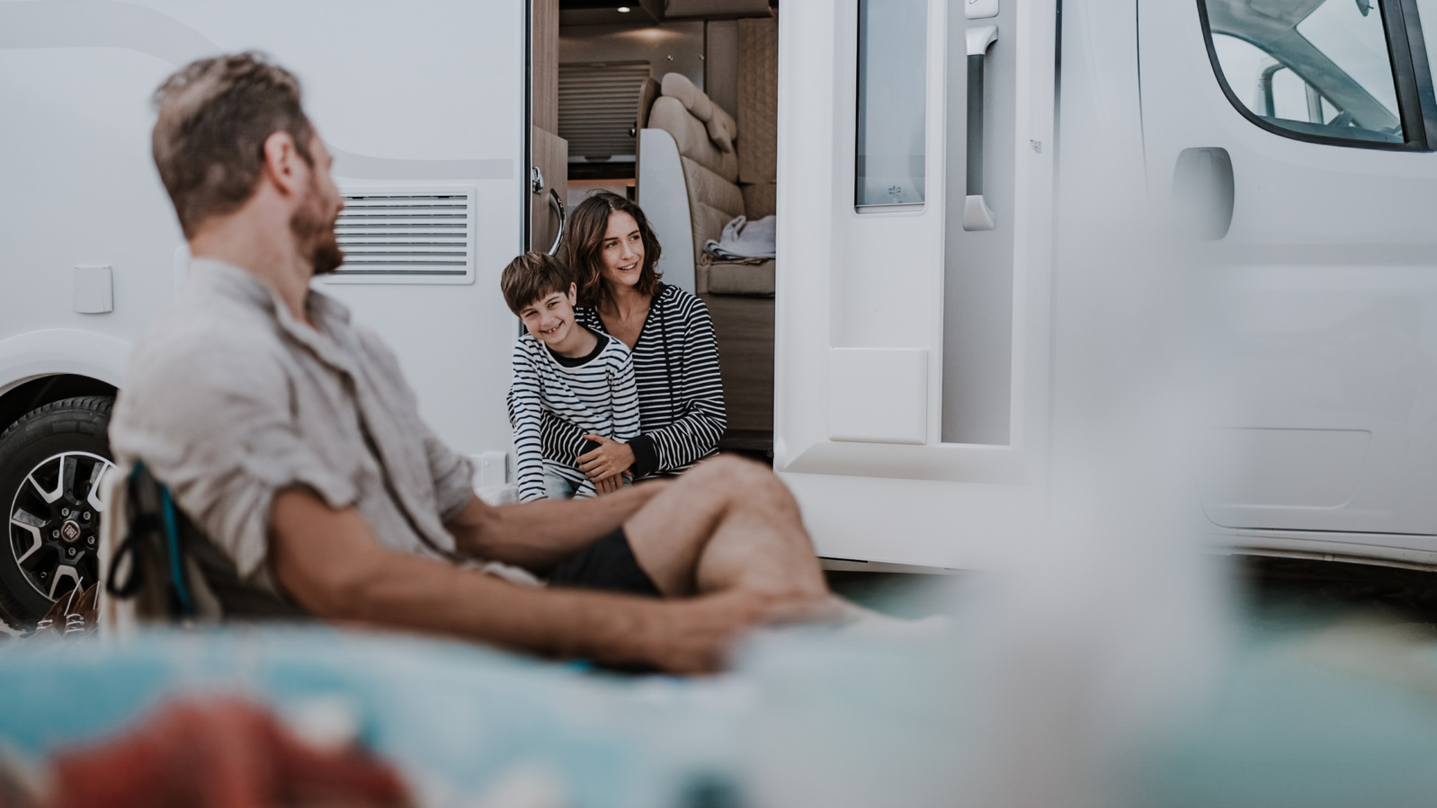 Famiglia con bambino davanti a un camper Laika